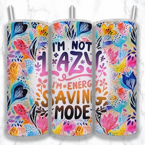 May include: A white tumbler with a colorful floral pattern and the text "I'm not lazy I'm energy saving mode".