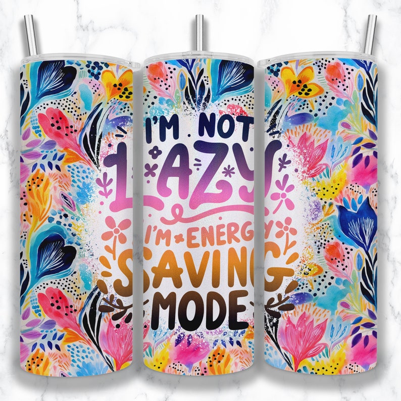 May include: A white tumbler with a colorful floral pattern and the text "I'm not lazy I'm energy saving mode".