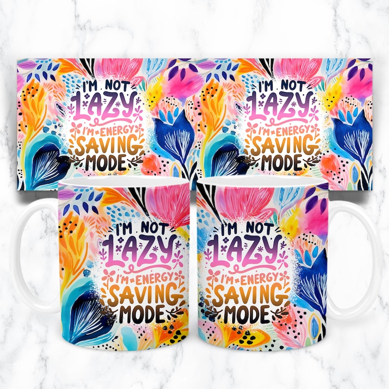 May include: White ceramic mug with a colorful floral design and the text "I'm not lazy I'm energy saving mode".