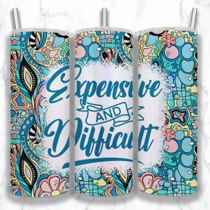 May include: A white tumbler with a blue and green floral pattern and the text "Expensive and Difficult" in blue lettering.