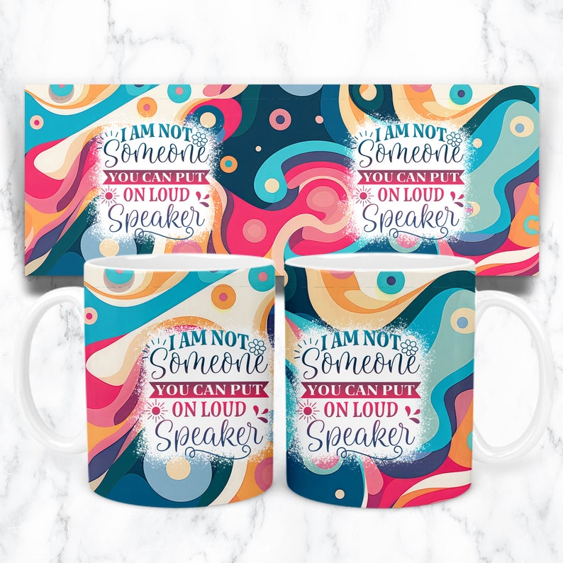 May include: Two white mugs with a colorful abstract design. The mugs feature the text "I am not someone you can put on loud speaker".