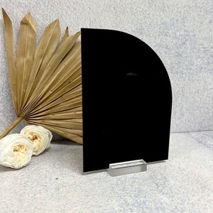 May include: A black acrylic half-circle sign with a clear acrylic stand. The sign is blank and ready for personalization.