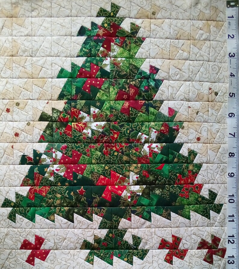 K&ouml;nnte beinhalten: Ein handgefertigter Weihnachtsbaum-Patchworkblock mit einem Patchwork-Design aus gr&uuml;nem, rotem und goldenem Stoff. Der Block besteht aus kleinen Quadraten und Dreiecken und bildet ein festliches und komplexes Muster.
