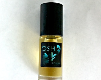 May include: A clear glass bottle with a black cap and a black label that says "DSH PERFUMES" in white text. The label has a teal blue design.