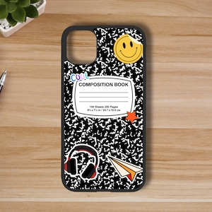 May include: Black phone case with a composition notebook design. The case has a smiley face, a red star, a paper airplane, and headphones on it. The text on the case reads "COOL COMPOSITION BOOK 100 Sheets 200 Pages 9 1/2 x 7 1/2 in / 24.7 x 19.0 cm."