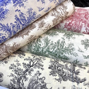 Può includere: Diversi rotoli di tessuto con motivi toile de Jouy in vari colori. I tessuti presentano scene dettagliate di persone, alberi ed edifici in tonalità di blu, marrone, verde, rosso e nero su sfondo crema. I rotoli sono impilati.