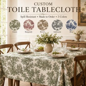 Può includere: Tovaglia toile personalizzata con un design di alberi e figure verdi. La tovaglia è su un tavolo di legno apparecchiato per un pasto. L'immagine mostra la tovaglia in verde, bordeaux, marrone, antracite e blu.