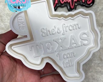 May include: A white plastic mold in the shape of Texas, with the text "She's from TEXAS I can tell." The mold is held by a hand. Logos for "CKO Creations" and "Deep South Freshie Co." are visible.