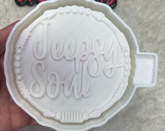 May include: White silicone mold for making a round resin ornament with the words "Jeep Soul" in a cursive font.