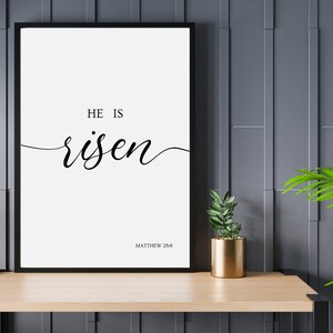 A picture frame of black text on a white background.  The bible verse "He is Risen." from Matthew 28:6.