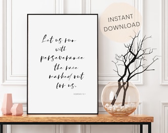 May include: Black and white printable wall art with a quote from Hebrews 12:1, "Let us run with perseverance the race marked out for us." The quote is in a modern calligraphy font and is framed in a black frame. The print is displayed on a wooden table with a vase of branches and white stones.