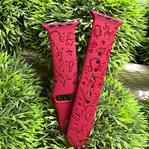 May include: Red Apple Watch band with a music-themed design. The band features a variety of musical symbols, including headphones, microphones, guitars, and music notes.
