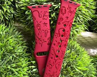 May include: Red Apple Watch band with a music-themed design. The band features a variety of musical symbols, including headphones, microphones, guitars, and music notes.