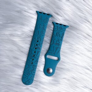 May include: Two teal blue silicone Apple Watch bands with a camping themed design. The bands feature a variety of camping icons, including a tent, compass, campfire, and hiking boots.