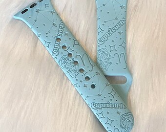 May include: A light blue Apple Watch band with a constellation and "Capricorn" design.