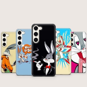 Op de afbeelding: Een verzameling telefoonhoesjes met Bugs Bunny uit Looney Tunes. De hoesjes tonen verschillende ontwerpen, waaronder Bugs Bunny in smoking met een sigaret en andere cartoonafbeeldingen. De hoesjes zijn in verschillende kleuren, waaronder zwart, blauw en geel.