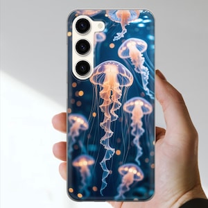 May include: A phone case featuring a vibrant design of glowing jellyfish against a deep blue background. The jellyfish have orange and white details, creating a captivating underwater scene. The case has a clear, protective finish.