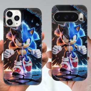 Puede incluir: Fundas para tel&eacute;fono con un dise&ntilde;o dividido de Sonic the Hedgehog. Un lado es azul, el otro negro. Las fundas tienen un dise&ntilde;o de suelo agrietado con efectos de rel&aacute;mpagos. El personaje est&aacute; en una pose din&aacute;mica, listo para la acci&oacute;n.