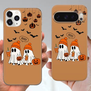 May include: Two phone cases with a Halloween design. Each case shows a cartoon ghost wearing an orange beanie and holding a drink, with a pumpkin and the word "BOO!". The background is a brown colour with bats and jack-o'-lanterns.