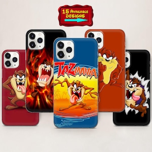 May include: A collection of phone cases featuring the Tasmanian Devil cartoon character. The cases display various designs, including the Taz character in different poses and settings, with vibrant colors and the "Taz Mania" logo. A sign indicates 15 available designs.