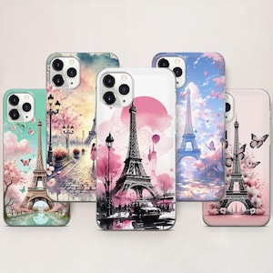 May include: Five phone cases with Eiffel Tower designs. Each case features a different watercolour illustration of the tower, with pink and blue skies, butterflies, and cherry blossoms. The cases have a clear border and a camera cutout.