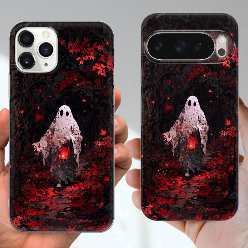 May include: Two phone cases with a spooky ghost design. The cases show a white ghost with a lantern, set against a dark forest background with red leaves. The cases are black and have cutouts for the phone's camera and buttons.