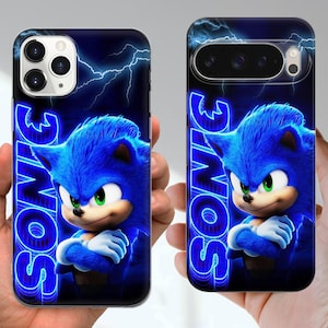 Puede incluir: Dos fundas para tel&eacute;fono con el personaje Sonic the Hedgehog. Las fundas tienen un fondo azul con rayos y la palabra "SONIC" en azul ne&oacute;n. El personaje es azul con ojos verdes.
