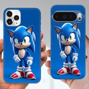 Puede incluir: Dos fundas azules para tel&eacute;fono con el personaje Sonic the Hedgehog. El personaje est&aacute; representado en 3D con pelaje azul, guantes blancos, zapatos rojos y blancos y ojos verdes. Las fundas se sostienen sobre un fondo azul.