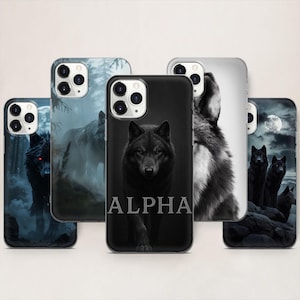 Può includere: Una collezione di custodie per telefoni con disegni di lupi. Le custodie presentano varie illustrazioni di lupi in bianco e nero e a colori, con sfondi di foreste e luna. Una custodia ha la parola "ALPHA" in bianco.