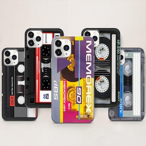 Puede incluir: Cinco fundas para teléfono con diseños de cintas de cassette retro. Las fundas presentan marcas como Maxell, Memorex y Sony. Los colores son negro, rojo, morado y azul.