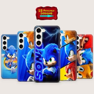 Puede incluir: Una colección de fundas para teléfonos con varios diseños del personaje Sonic the Hedgehog. Las fundas son principalmente azules, con imágenes de Sonic y otros personajes. Un letrero rojo encima de las fundas dice "15 AVAILABLE DESIGNS".