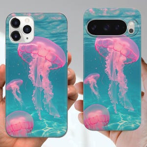 Puede incluir: Fundas de tel&eacute;fono con una vibrante escena submarina de medusas rosas. Las fundas tienen un fondo turquesa con reflejos de luz, creando un efecto oce&aacute;nico realista. Las medusas son el punto focal, con tent&aacute;culos detallados.