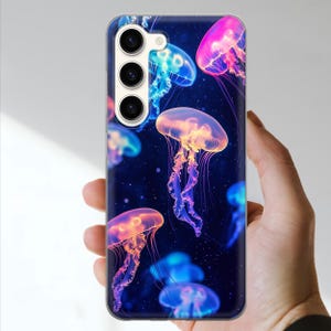 May include: A phone case featuring a vibrant design of glowing jellyfish against a dark blue background. The jellyfish are depicted in shades of pink, orange, and blue, creating a colorful and eye-catching pattern. The case has a glossy finish.