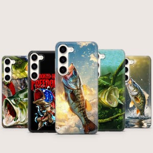 May include: A collection of phone cases featuring vibrant fish illustrations. Designs include a largemouth bass leaping from water, a fish with an open mouth, and a patriotic design with the text "Hooked on Freedom."