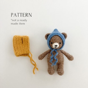 Peut inclure: Patron de crochet pour un ours en peluche brun portant un chapeau bleu et un bonnet crocheté jaune. Le patron n'est pas un produit fini.
