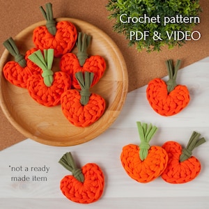Puede incluir: Corazones de ganchillo naranja brillante con tallos verdes, dispuestos en un plato de madera y una superficie blanca. La imagen incluye el texto "Crochet pattern PDF & VIDEO" y "*not a ready made item".