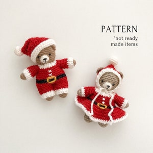 K&ouml;nnte beinhalten: Zwei geh&auml;kelte Teddyb&auml;ren, die rote und wei&szlig;e Weihnachtsmannkost&uuml;me tragen. Die B&auml;ren sitzen auf einem wei&szlig;en Hintergrund. Der Text "PATTERN *not ready made items" ist in der oberen rechten Ecke des Bildes sichtbar.