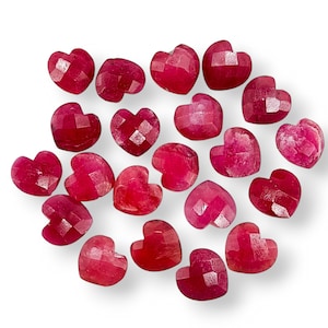 Puede incluir: Una colección de 20 cuentas de piedras preciosas rojas en forma de corazón. Las cuentas son facetadas y tienen un acabado brillante y pulido.