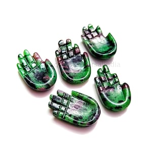 Może przedstawiać: Pięć zielonych i różowych rzeźbionych kamieni szlachetnych w kształcie dłoni. Rzeźby mają kształt otwartych dłoni z rozłożonymi palcami. Kamienie szlachetne są zielono-różowe.