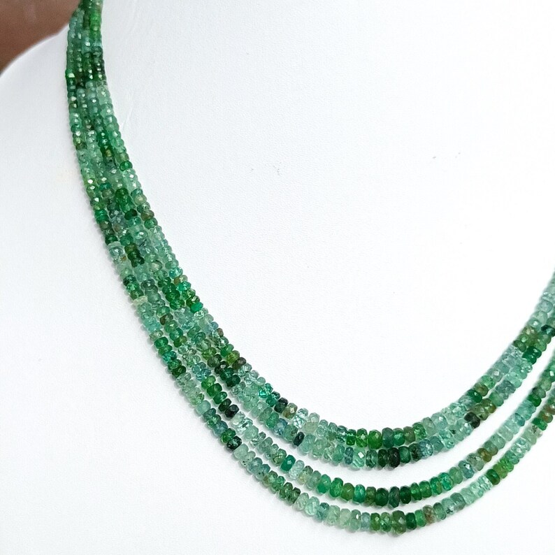 Pode incluir: Um colar de v&aacute;rias voltas feito de contas de esmeralda verde. As contas s&atilde;o facetadas e t&ecirc;m uma forma ligeiramente irregular. O colar tem aproximadamente 45 cm de comprimento.