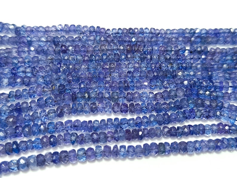 K&ouml;nnte beinhalten: Eine Str&auml;hne blauer Edelsteinperlen, jede Perle ist facettiert und hat eine quadratische Form.