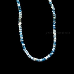 May include: A necklace made of blue and white gemstone beads. The beads are round and have a mottled appearance. The necklace is approximately 18 inches long.