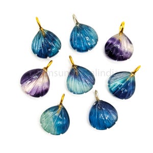 Puede incluir: Ocho colgantes de concha de fluorita azul, verde y morado con un cierre de oro. Cada colgante está tallado en forma de concha.