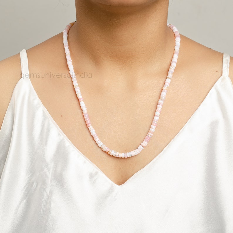May include: A delicate necklace made of small, pink and white opal beads. The necklace is approximately 18 inches long and is perfect for adding a touch of elegance to any outfit.