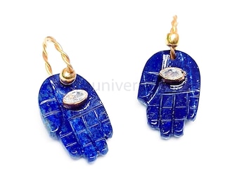 Könnte beinhalten: Ein Paar blaue Lapislazuli-Ohrringe in Form von Händen mit einem klaren Edelstein in der Mitte jeder Hand.