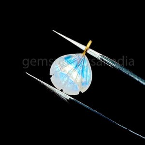 May include: A white moonstone pendant with a gold bail. The moonstone has a blue iridescent sheen.