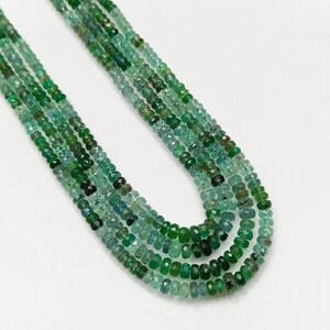 Pode incluir: Um colar de v&aacute;rias voltas de contas de esmeralda verde, com forma facetada ligeiramente irregular. As contas s&atilde;o enfiadas em um fio transparente.