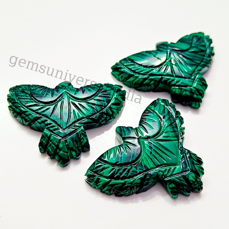 May include: Three green malachite gemstone carvings of birds. Each bird is intricately carved with detailed feathers and a wingspan of approximately 2 inches.