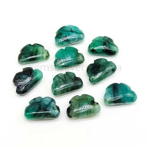 Könnte beinhalten: Zehn grüne Smaragd-Edelsteine ​​Cabochons, die in Form von Wolken geschnitzt sind. Die Edelsteine ​​sind poliert und haben eine glatte, glänzende Oberfläche.
