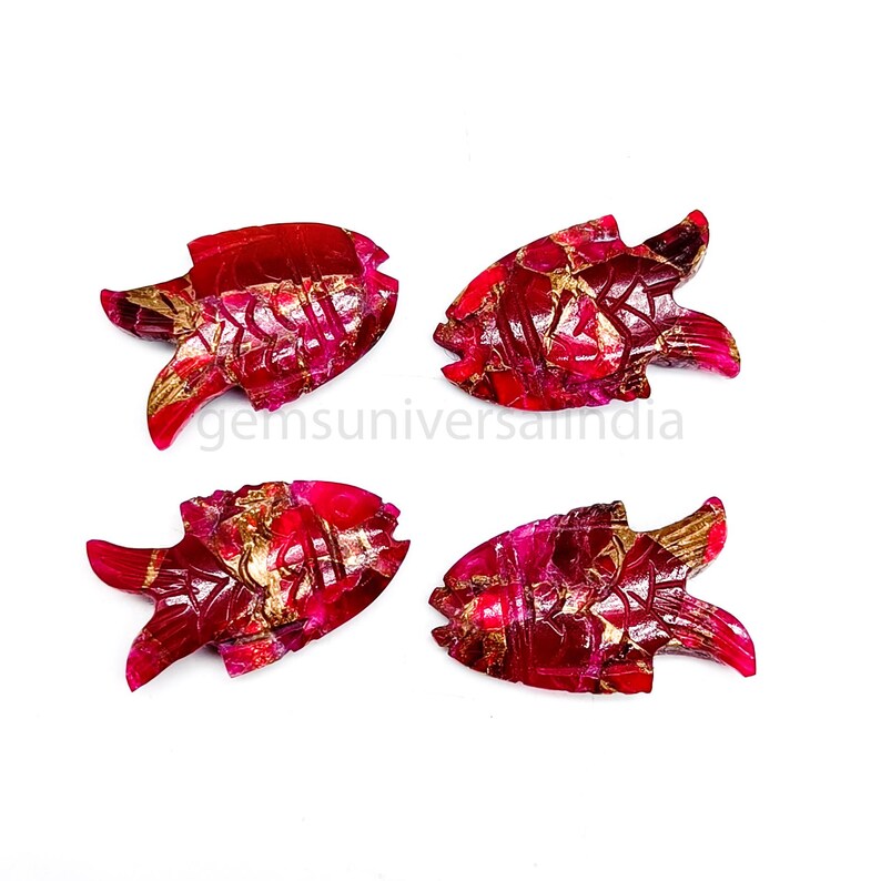 May include: Four red ruby fish carvings with gold accents. The fish are carved in a detailed style and have a glossy finish.